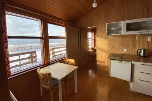 kuchnia ze stołem i 2 krzesłami oraz 2 oknami w obiekcie Sudur-Bár Guesthouse w mieście Grundarfjordur