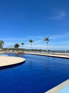 una gran piscina junto a una playa con palmeras en Golden Lake - 1 quarto, en Arraial do Cabo