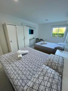 Habitación con 2 camas y ventana en Golden Lake - 1 quarto, en Arraial do Cabo
