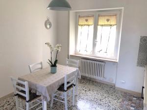 a dining room with a table and chairs and two windows at Casa Matilde & Aurora con giardino e posto auto privato in Sirolo +5 photos