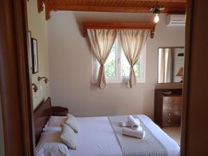 a bedroom with a bed and a window with towels on it at Katerina house in Finikounta
