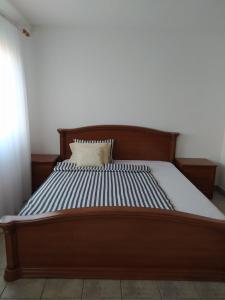 uma cama com uma estrutura de madeira com uma almofada em Sobe kod bolnice Paprikovac em Banja Luka