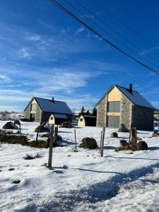 dos casas en un campo cubierto de nieve con nieve en BURON FRANCk, en Aubrac