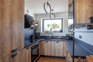 cocina con armarios de madera, fregadero y ventana en BURON FRANCk, en Aubrac