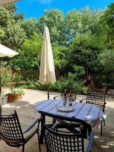 a patio table with a white umbrella and chairs at Villa Agava in Vrboska