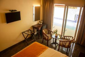 une chambre d'hôtel avec un lit et une table avec des chaises dans l'établissement Serene Sriperumbudur, à Kāndūr