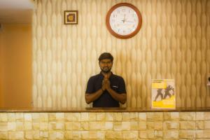 Kāndūr的住宿－Serene Sriperumbudur，一位与本教信徒站在柜台上的人