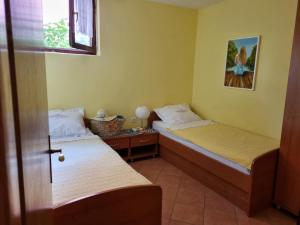 a room with two beds and a table with a window at Villa Agava in Vrboska