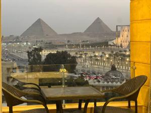 a table and chairs with a view of the pyramids at Asia Grand Museum & Pyramids view in Cairo