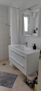 a white bathroom with a sink and a mirror at Apartment Lia in Beerfelden