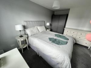 a bedroom with a white bed and a night stand at Very comfy 3 bed town house in Ashton under Lyne