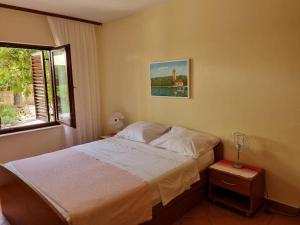 a small bedroom with a bed and a window at Villa Agava in Vrboska