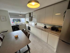 a kitchen with a table and a dining room at Very comfy 3 bed town house in Ashton under Lyne