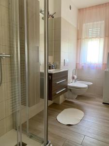 a bathroom with a shower and a sink and a toilet at Appartamento Verdebleu - Lago e Terme in Levico Terme