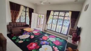 een woonkamer met een bank en een bloemenpapier bij HOMESTAY AT-TAQWA BATU PAHAT in Batu Pahat