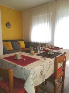 Habitación con mesa y mantel rojo y blanco en Appartamento Verdebleu - Lago e Terme, en Levico Terme
