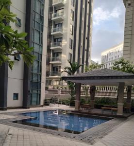 uma piscina com um gazebo e edifícios em Condotel Near Airport at Two Palmtree Villas em Manila