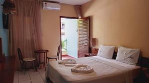 a bedroom with a bed with two towels on it at Albacora Praia Hotel in Japaratinga +46 photos