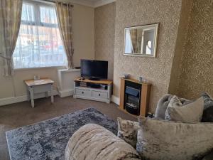 een woonkamer met een bank en een tv bij hewitt place in Crewe