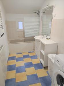 uma casa de banho com piso xadrez azul e amarelo em Une Parenthèse Enchantée em Saint-Sébastien-sur-Loire