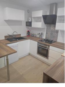 uma cozinha com armários brancos e um forno com placa de fogão em Une Parenthèse Enchantée em Saint-Sébastien-sur-Loire