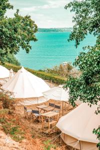a group of tents with the ocean in the background at Lodg'ing Nature Camp Presqu'île Crozon in Lanvéoc