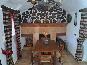 a dining room with a table and a fireplace at CASA CUEVA LOS HONORIOS in Cortes de Baza