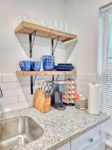 una encimera de cocina con platos y cuencos en estanterías en Cozy 1 Bed 1 Bath, Centrally Located, Self-check-in, en Houston
