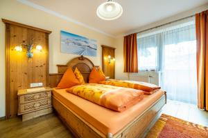 ein Schlafzimmer mit einem großen Bett mit einer orangefarbenen Bettdecke in der Unterkunft Appartement Jäger in Flachau