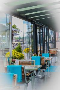 uma fila de mesas e cadeiras num edifício com janelas em Hotel de Boegschroef em Delfzijl