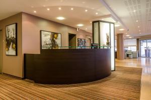 a lobby with a reception desk in a building at Helgon Hotel - Lourdes Pyrénées in Lourdes