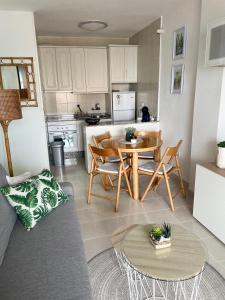 cocina y sala de estar con mesa y sillas en Oasis Paradise Apartment La Manga en La Manga del Mar Menor