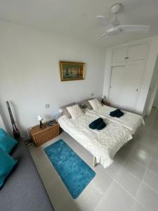 1 dormitorio con 2 camas y alfombra azul en Oasis Paradise Apartment La Manga en La Manga del Mar Menor