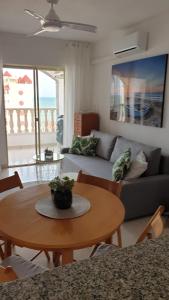 sala de estar con mesa y sofá en Oasis Paradise Apartment La Manga en La Manga del Mar Menor