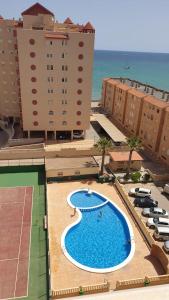 una vista aérea de una piscina con edificios y el océano en Oasis Paradise Apartment La Manga en La Manga del Mar Menor