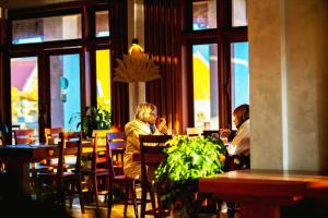 dos personas sentadas en una mesa en un restaurante en KNN Luxury Hill en Sen Monorom