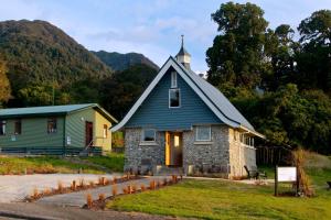 a small church with a steeple on top of it at The Church at Fox in Fox Glacier