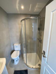 La salle de bains est pourvue de toilettes et d'une douche en verre. dans l'établissement Spectacular Modern, Brand-New, 1 Bed Flat, 15 Mins Away From Central London, à Hendon