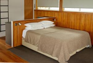 a bedroom with a bed with a wooden headboard at The Church at Fox in Fox Glacier