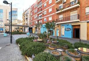 uma rua com um jardim de plantas e edifícios em Alojamiento Simón 3 em Múrcia