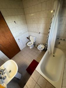 a bathroom with a tub and a sink and a toilet at La Contención in Mar Azul