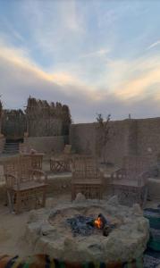 a fire pit in a patio with chairs and tables at Friendo's House & Hot Spring in Siwa