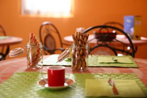 a table with a green table cloth with utensils in jars at Villa Camurana in Medolla