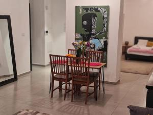 a dining room table with chairs and a vase of flowers at Lovely garden Flat in Tel Aviv in Tel Aviv