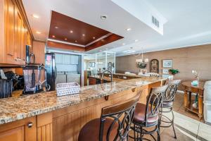a kitchen with a bar with chairs and a fish tank at La Concha 5 in Clearwater Beach