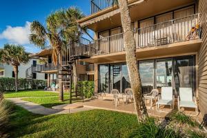 an exterior view of a house with patio furniture and palm trees at La Concha 5 in Clearwater Beach
