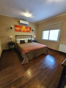 1 dormitorio con 1 cama grande y suelo de madera en Departamento Caseros Desings en Salta