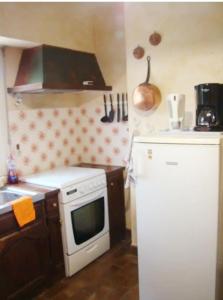 uma cozinha com um fogão branco e um frigorífico em AU GRAND PIN em Fouesnant