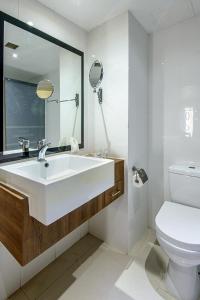biała łazienka z umywalką i toaletą w obiekcie Gazelle International Hotel w Kokopo