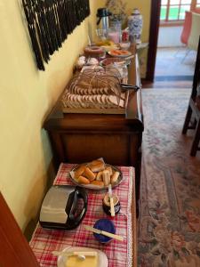 a buffet line with bread and pastries on a table at Suítes Monte Belo in Campos do Jordão